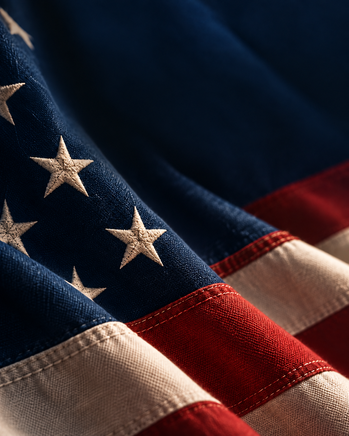 Close-up American flag fabric in navy, ivory, and restrained red.